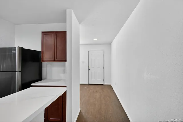 a kitchen with a refrigerator sink and wooden floor