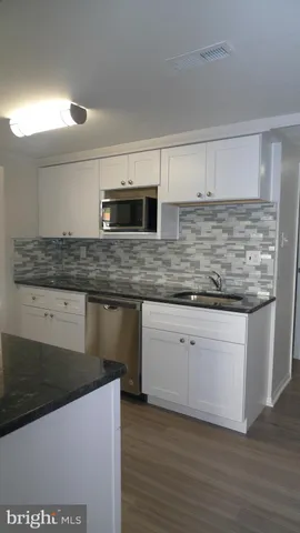 a kitchen with stainless steel appliances kitchen island granite countertop a stove a sink and a microwave