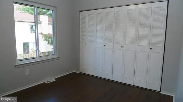 a view of a small space with wooden floor and a window