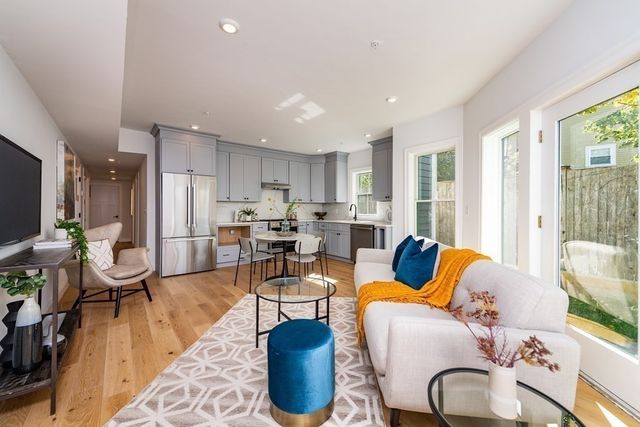 a living room with furniture kitchen and a large window