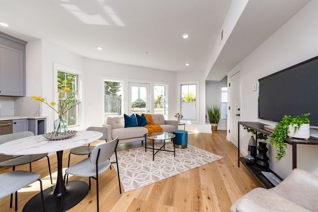 a living room with furniture a wooden floor and a flat screen tv