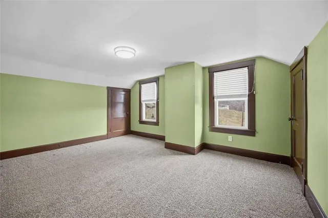 an empty room with a window and a chair