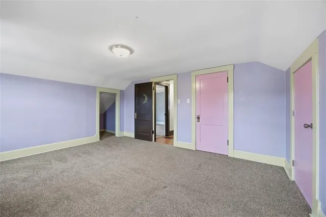 a view of an empty room with closet and a window