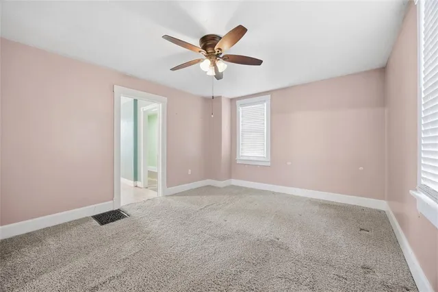 an empty room with fan and windows