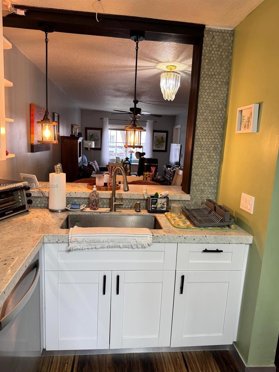 2931 Southeast 12th Road, Unit 10555 Homestead, FL 33035 - Photo 6 of 21 a view of a kitchen with kitchen island a counter top space appliances and a living room view