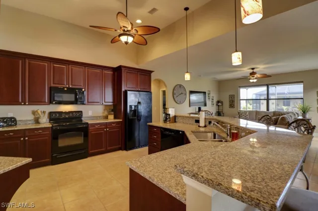 a kitchen with stainless steel appliances granite countertop a sink refrigerator stove and microwave