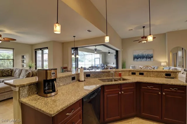 a kitchen with a stove a sink a counter space and living room