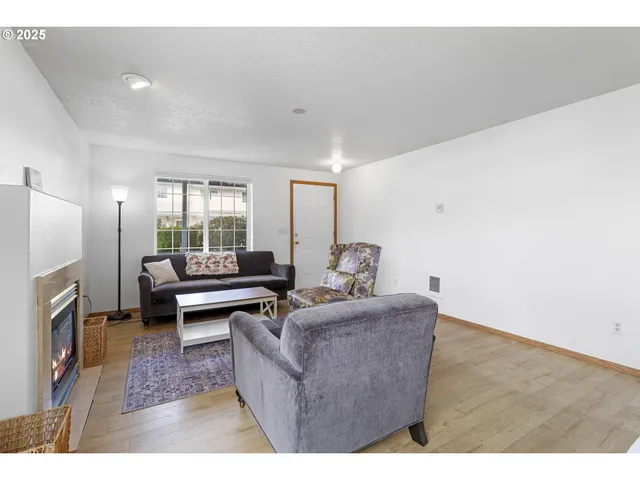 a living room with furniture wooden floor and a fireplace