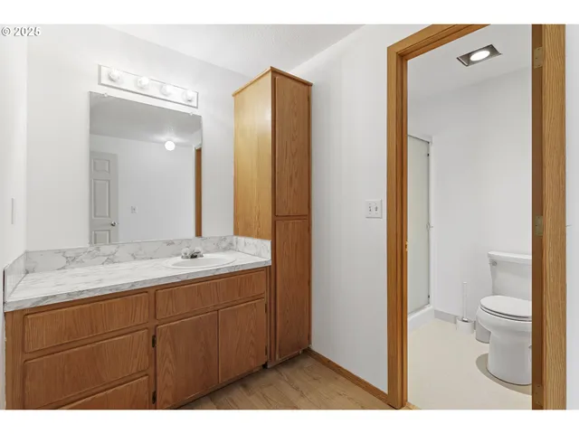 a bathroom with a granite countertop sink toilet and shower