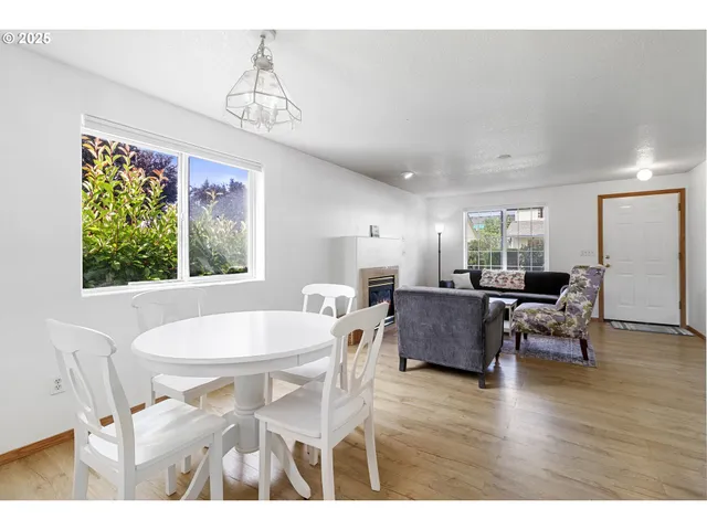 a dining room with wooden floor a chandelier a wooden table and chairs