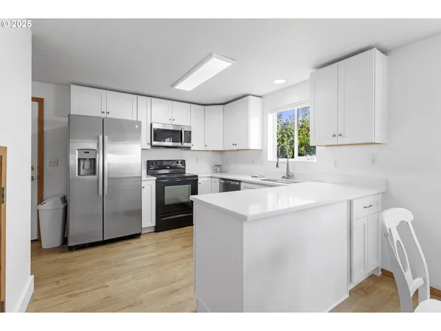a kitchen with kitchen island a refrigerator sink and cabinets