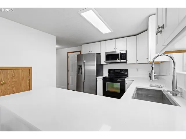 a kitchen with granite countertop a refrigerator and a sink