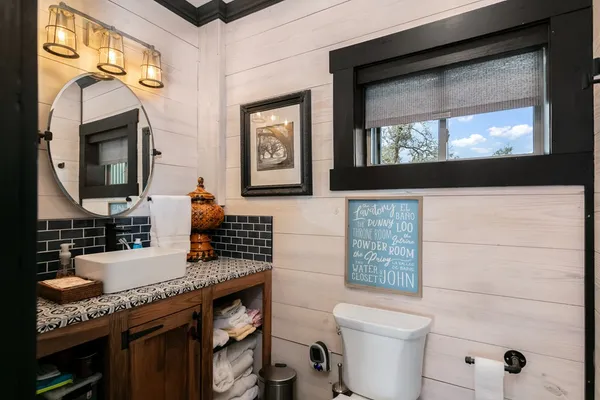 a bathroom with a granite countertop toilet sink and mirror