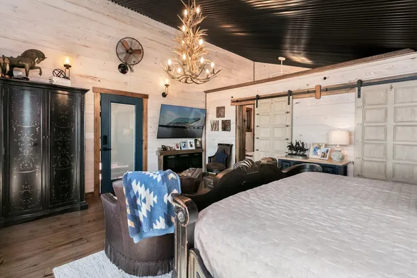 a living room with furniture a chandelier and a flat screen tv