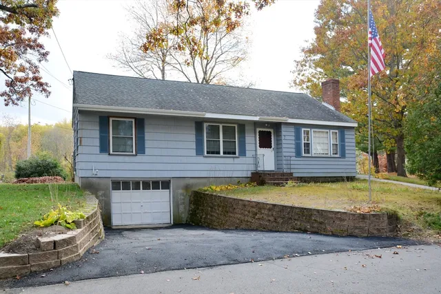 a view of a house with a yard and large tree