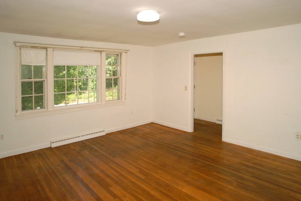 7 Howard Street Milford, MA 01757 - Photo 11 of 22 a view of an empty room with wooden floor and a window