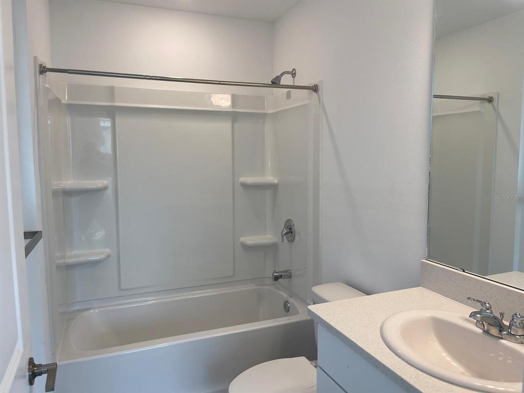 3335 Composition Street Kissimmee, FL 34758 - Photo 14 of 22 a bathroom with a granite countertop bathtub shower sink vanity and toilet