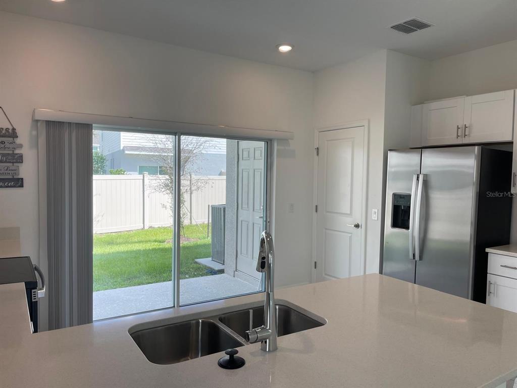 3335 Composition Street Kissimmee, FL 34758 - Photo 7 of 22 a kitchen with a window a sink and a refrigerator