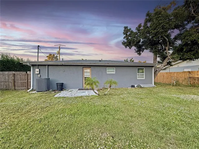 a view of a house with a backyard and a tree