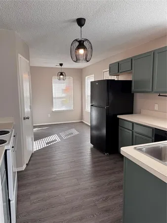 a kitchen with stainless steel appliances granite countertop a refrigerator a sink dishwasher a stove and a refrigerator