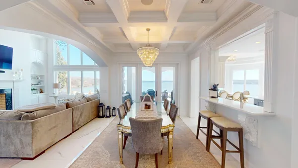 a living room with furniture a chandelier and a large window