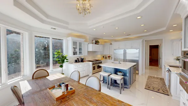 a living room with furniture a chandelier and a dining table