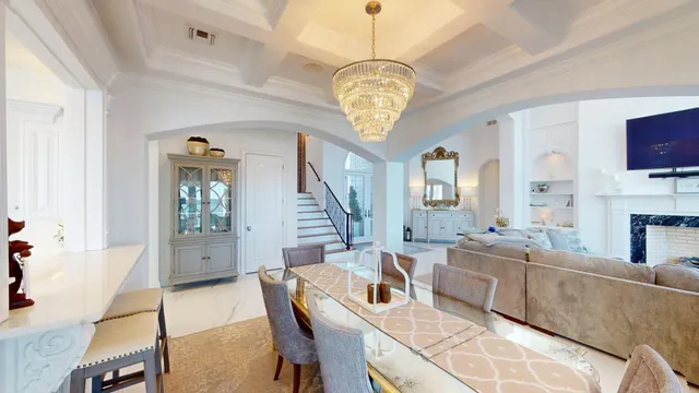 a very nice looking dining room with a large dining table and a chandelier