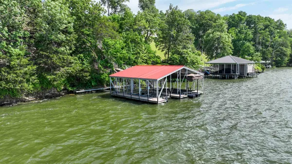a view of a lake with two chairs and a table