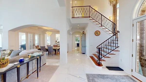 a living room with furniture a chandelier and a large window