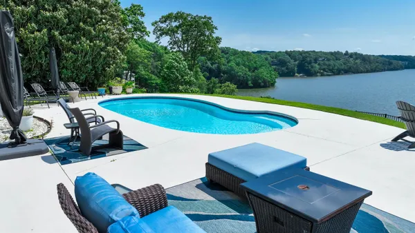 a view of a swimming pool with seating area and furniture