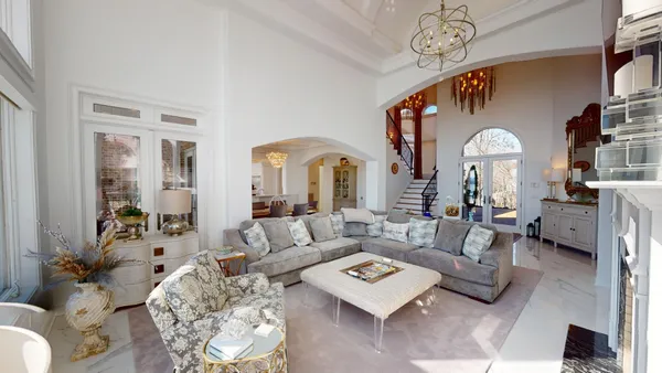 a living room with furniture a table and a chandelier