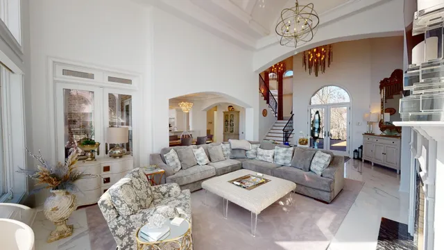 a living room with furniture a table and a chandelier