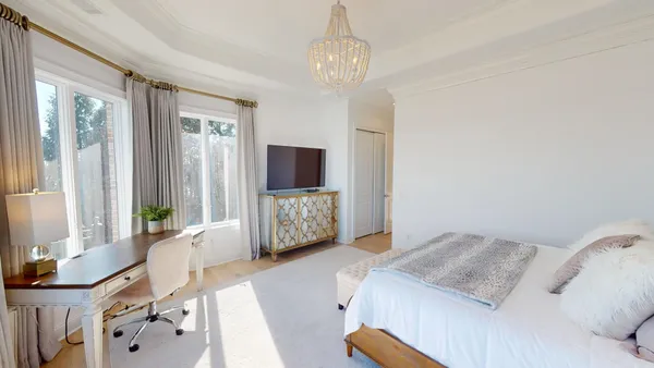 a spacious bedroom with a bed and a flat screen tv