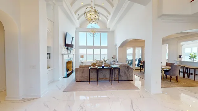 a living room with furniture a chandelier and a large window
