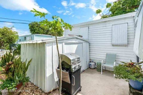 a view of a chair and table in backyard of the house
