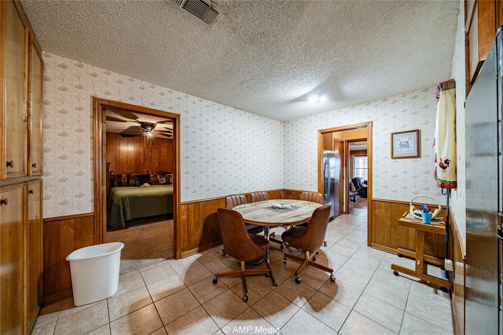 1992 Sand Flat Road Jacksboro, TX 76458 - Photo 27 of 36 Dining area featuring ceiling fan, light tile patterned floors, and a textured ceiling