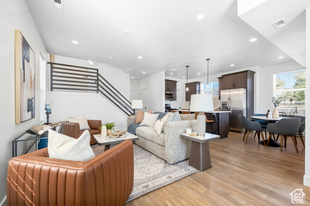 153 East Rochefort Court Sandy, UT 84070 - Photo 6 of 43 Open-concept living space with wood-finish flooring, recessed lighting, and a modern horizontal stair railing