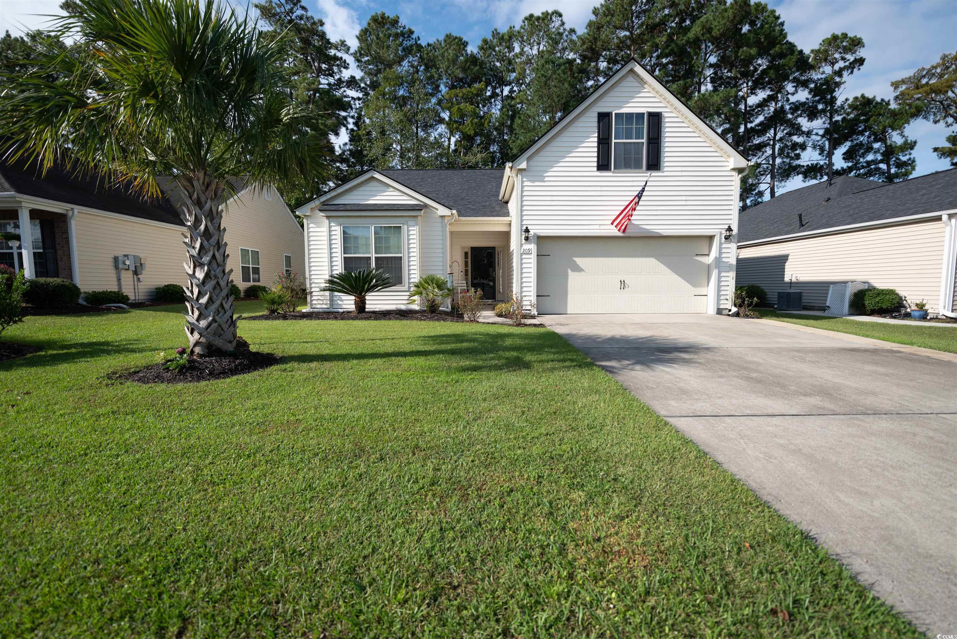 Traditional-style home with driveway, a front lawn, and a garage