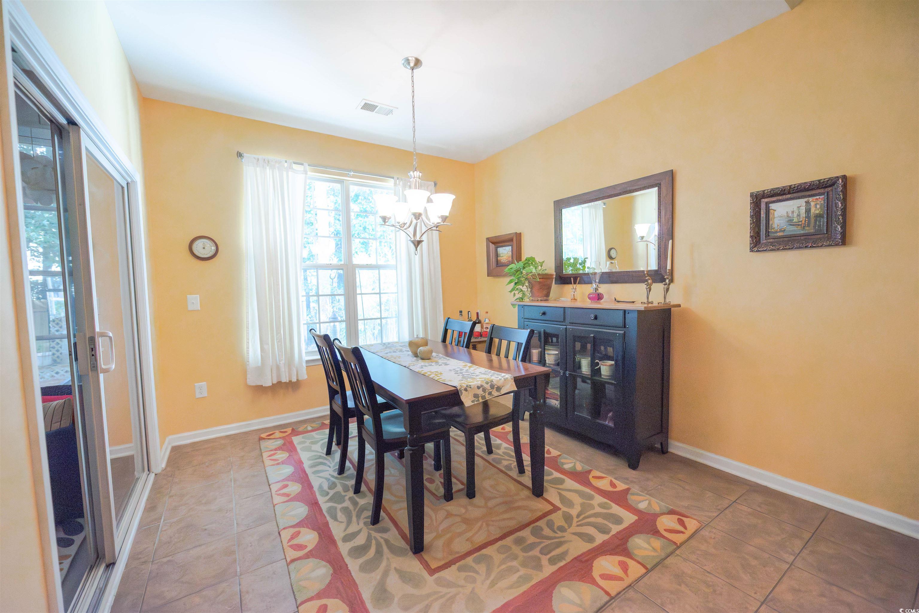 209 Golden Oaks Drive Murrells Inlet, SC 29576 - Photo 14 of 40 Dining space featuring light tile patterned flooring, a chandelier, and plenty of natural light