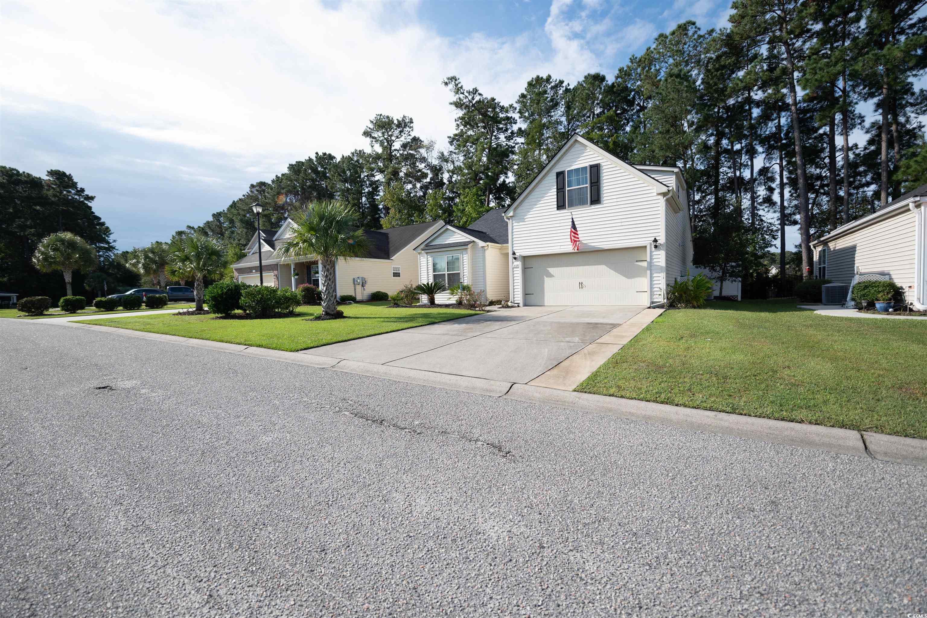209 Golden Oaks Drive Murrells Inlet, SC 29576 - Photo 2 of 40 Traditional-style home with a front yard, driveway, and an attached garage