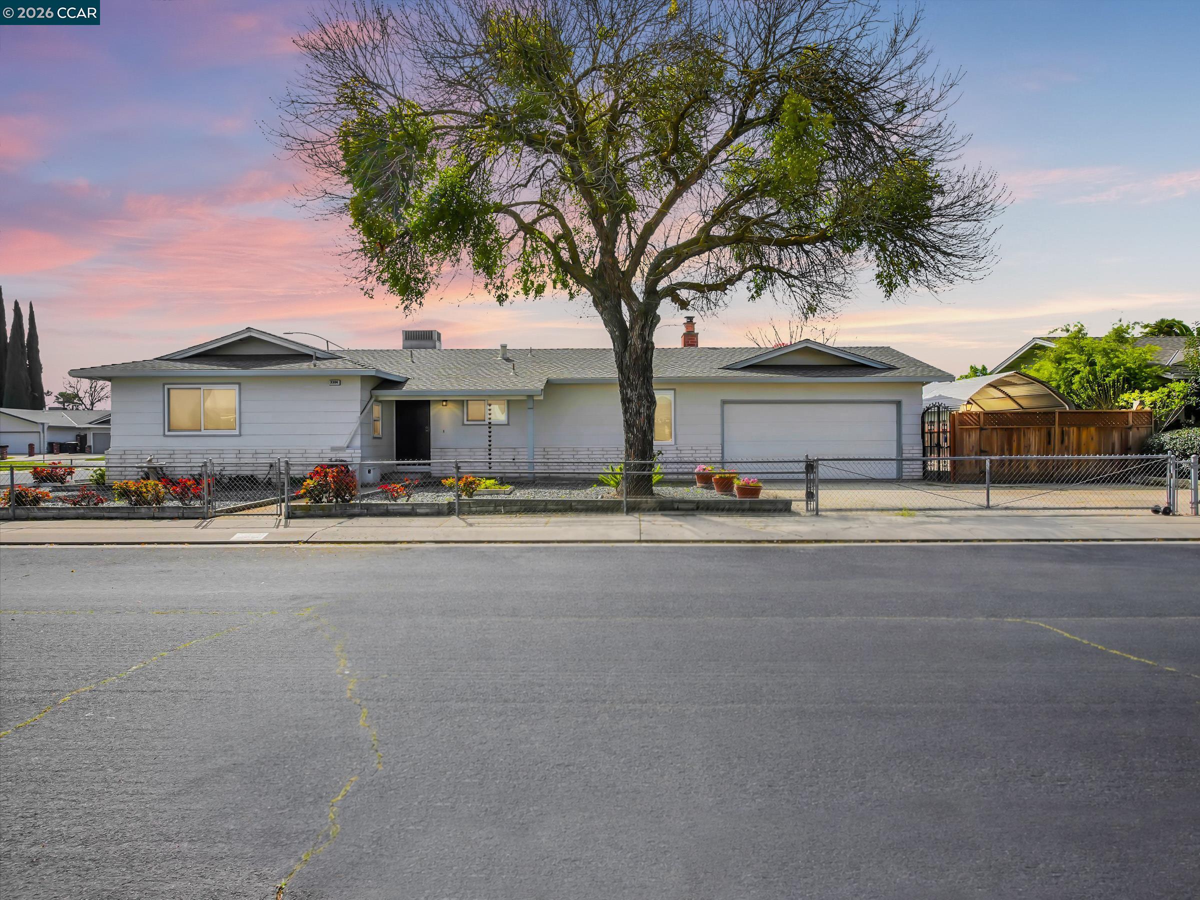 3304 Swallow Drive Modesto, CA 95356 - Photo 1 of 1 a front view of a house with a garden and tree