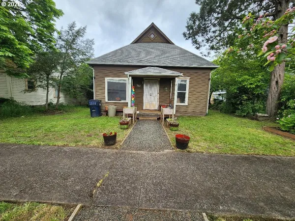 a front view of a house with garden and trees