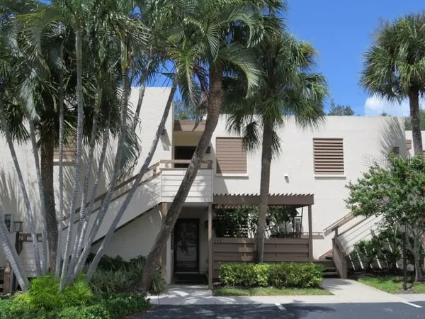 a front view of a house with a tree