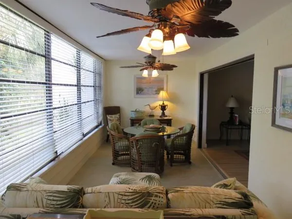 a living room with furniture a chandelier and a dining table