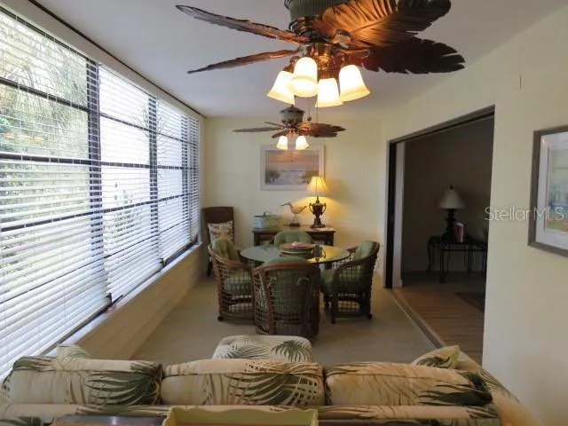 a living room with furniture a chandelier and a dining table