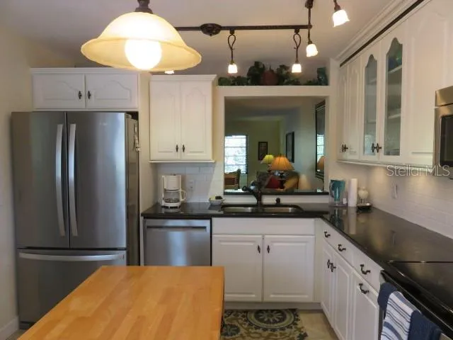 a kitchen with stainless steel appliances a sink a stove and refrigerator