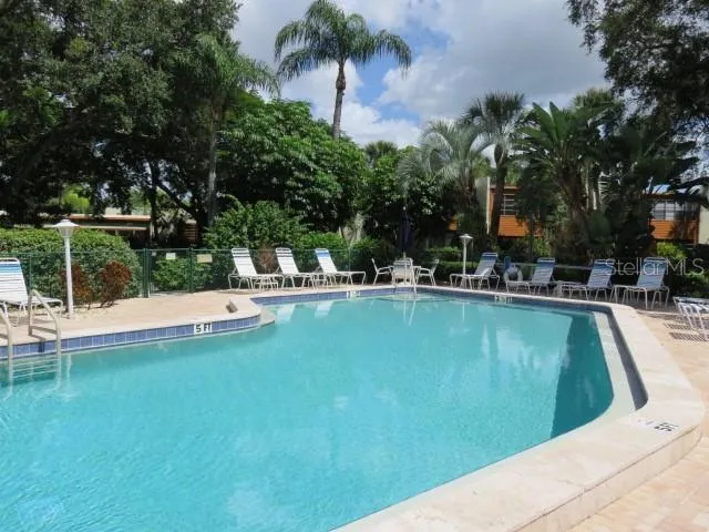 a view of a house with swimming pool and sitting area