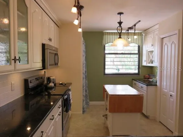 a kitchen with a sink stove and microwave