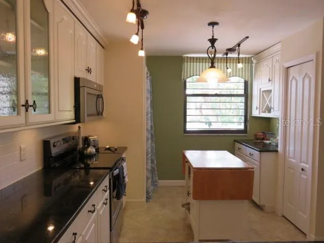 a kitchen with a sink stove and microwave