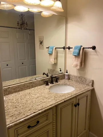 a bathroom with a granite countertop sink and a mirror
